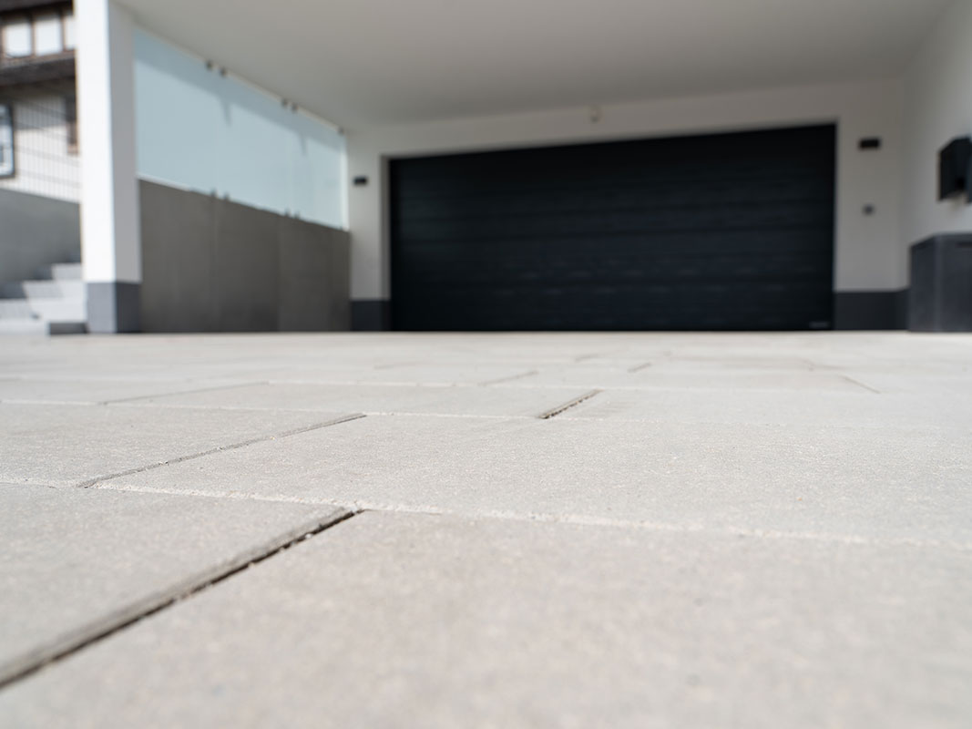 Detailaufnahme der gepflasterten Einfahrt in der Gartenanlage der Familie Grimm in Niedereschach, mit Betonsteinen in elegantem Grau.