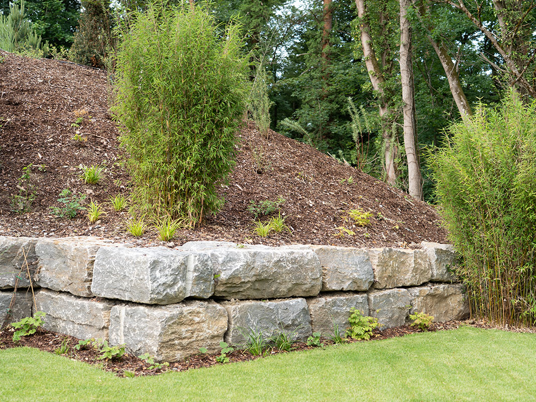 Steinmauer aus großen Steinen, darauf erhoben Grasflächen und Torfboden