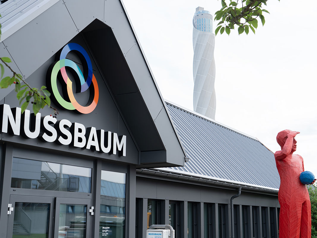 Außenansicht des Nussbaum-Gebäudes mit roter Skulptur vor dem Eingang.